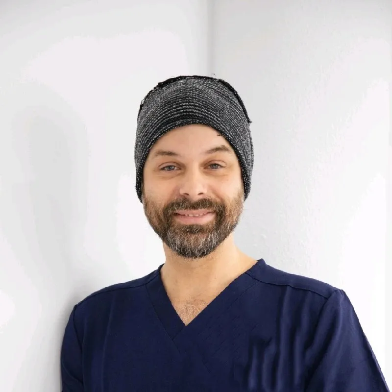 Dr Tristan Maugueret in navy scrubs, smiling.